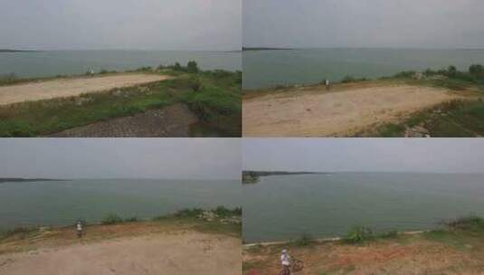 武汉梁子湖骑行单人望向湖面航拍高清在线视频素材下载