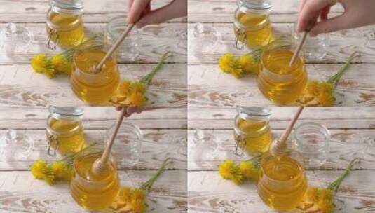 女人用勺子蘸蒲公英蜂蜜在罐子上桌子高清在线视频素材下载