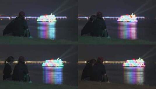 两人坐在江边看长江游船夜景高清在线视频素材下载