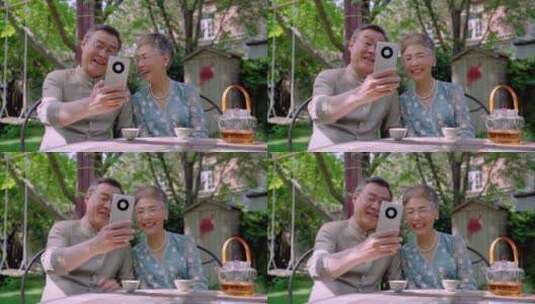 老年夫妇坐在院子里使用手机高清在线视频素材下载