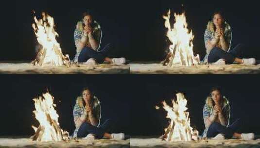 女孩坐在篝火边喝茶高清在线视频素材下载