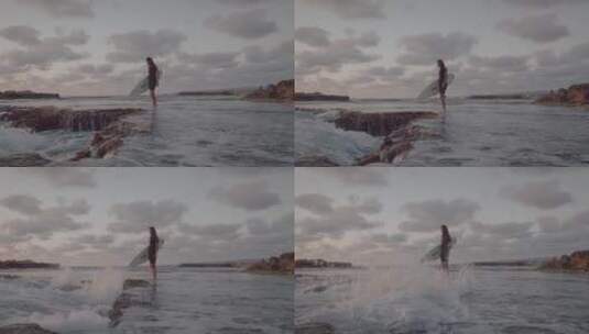 一个人拿着冲浪板站在海滩上高清在线视频素材下载