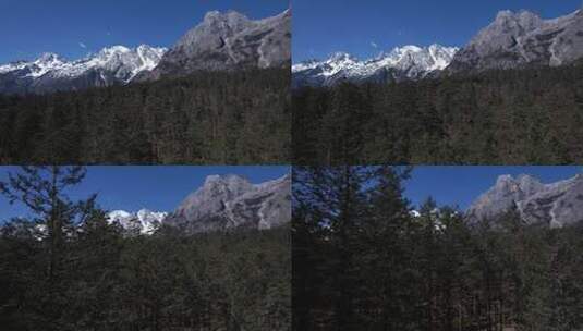 航拍晴天的雪山和原始森林高清在线视频素材下载