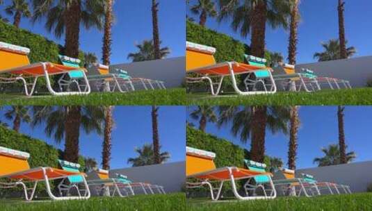 棕榈泉一户人家的游泳池周围坐着五颜六色的草坪椅高清在线视频素材下载