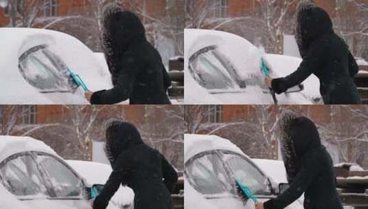 女人在冬天打扫车上的雪高清在线视频素材下载