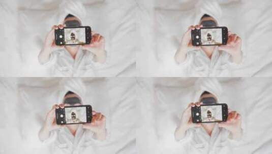 面膜女人躺在床上用手机拍照高清在线视频素材下载