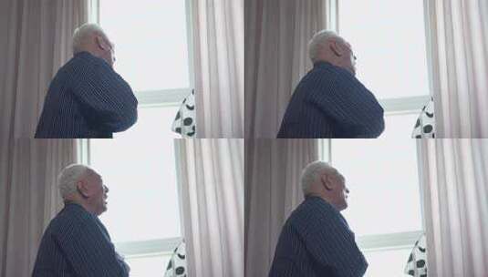 老人室内窗边站立远望高清在线视频素材下载