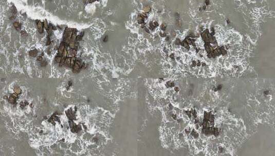 大海俯拍礁石浪花海水拍打礁石阴天海水浑浊高清在线视频素材下载