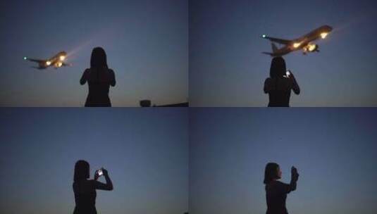 黄昏美女模特用手机拍摄飞机降落高清在线视频素材下载