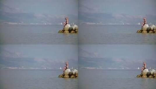 坐在海边岩石上的女人高清在线视频素材下载