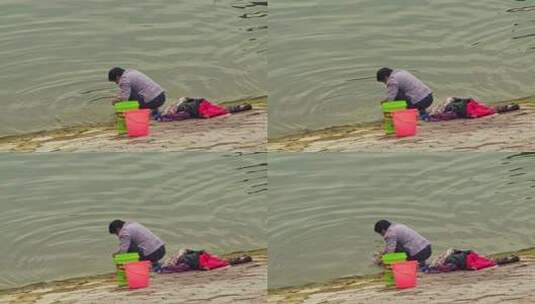 江岸边洗衣服的女人高清在线视频素材下载