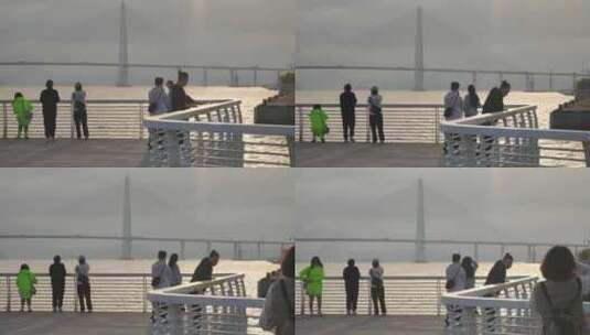 游客在海湾亲水平台眺望大桥打卡拍照高清在线视频素材下载