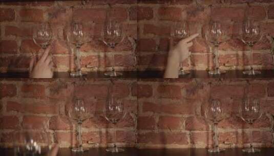 从砖墙架子上取下红酒杯高清在线视频素材下载
