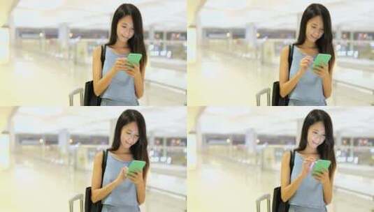 女人在机场看手机高清在线视频素材下载