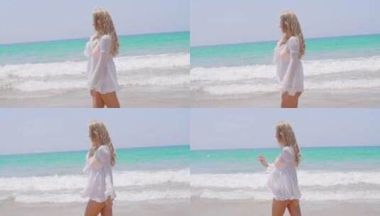 金发女孩穿着白色束腰外衣在海滩上散步高清在线视频素材下载