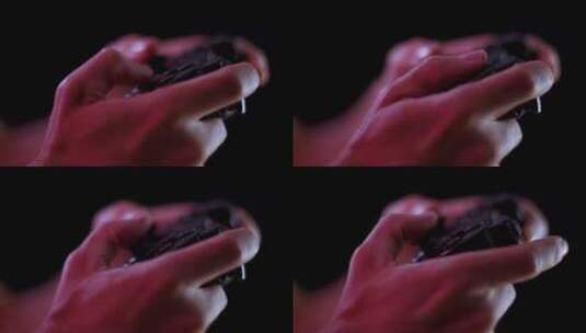 在黑暗的房间里玩电子游戏，黑色背景特写在一个小控制器按钮上高清在线视频素材下载