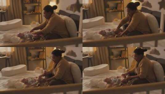 快乐的妈妈在卧室里为新生儿换尿布高清在线视频素材下载