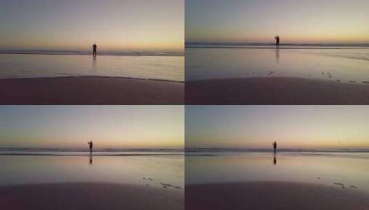 日落时一个男人沿着海洋散步的剪影高清在线视频素材下载