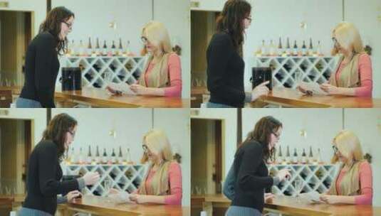 一个女人在一家小酒厂品尝葡萄酒，与卖家交流高清在线视频素材下载