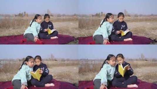 冬季在公园草坪上看书的两个女孩高清在线视频素材下载