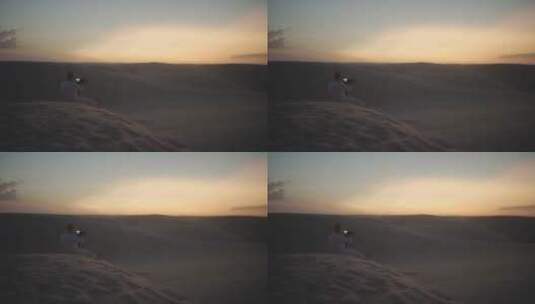 男人在沙漠拍摄日落美景高清在线视频素材下载
