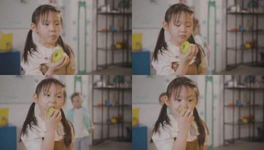小女孩在教室里吃苹果高清在线视频素材下载