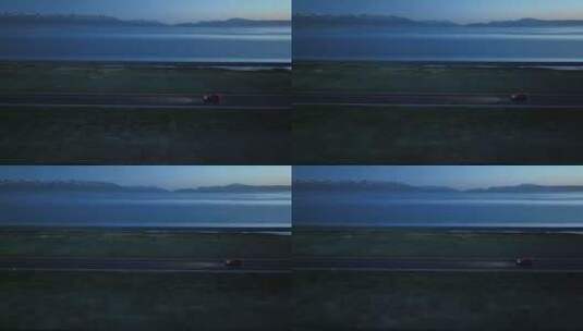 黄昏时分航拍汽车行驶在赛里木湖环湖公路上高清在线视频素材下载