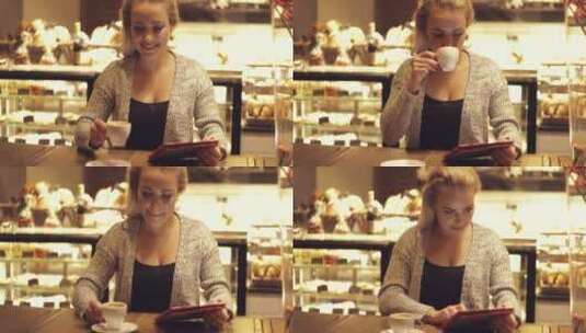 女人坐在咖啡馆喝咖啡使用平板电脑高清在线视频素材下载