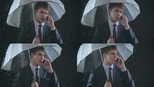 男人在雨中撑伞打电话高清在线视频素材下载