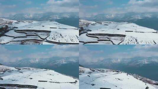 冬季白雪覆盖山川田野农田庄稼远处连绵雪山高清在线视频素材下载