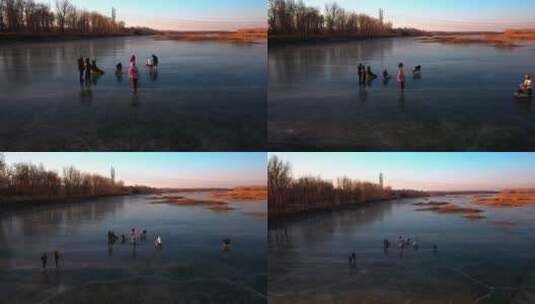 航拍冬季在结冰的河流冰面上滑冰玩耍的游人高清在线视频素材下载