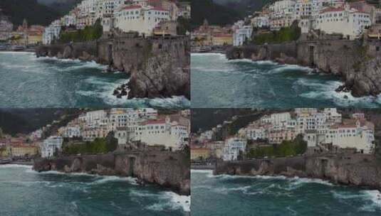 海岸悬崖上的海滨酒店，海浪拍打着。白天意大利南部的阿马尔菲海岸。aer高清在线视频素材下载