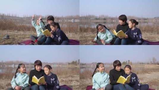 冬季在公园草坪上看书的母亲和两个女儿高清在线视频素材下载