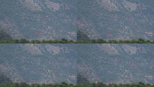 滑翔伞飞过森林覆盖的山脉高清在线视频素材下载