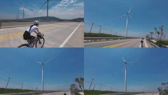 航拍美女骑自行车公路蓝天白云风力发电机高清在线视频素材下载