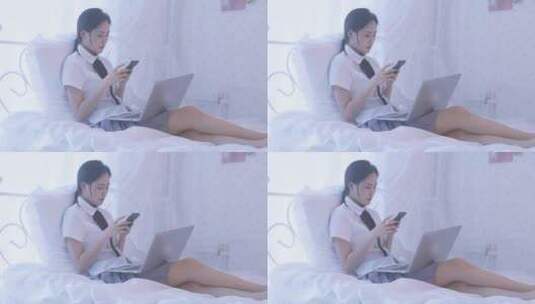 一名东方女性在卧室床上坐着玩手机高清在线视频素材下载