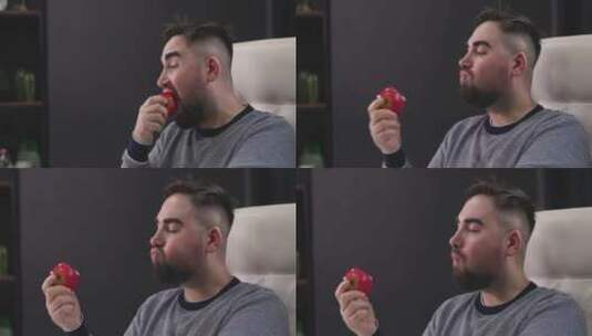 坐在书桌前吃红苹果的男人高清在线视频素材下载