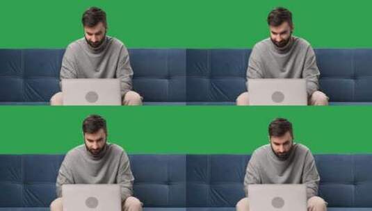 男人远程工作笔记本电脑聊天浏览互联网沙发隔离绿屏色度键高清在线视频素材下载