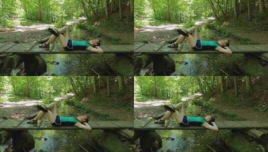 一个躺在木制小径上在森林里放松的女人高清在线视频素材下载