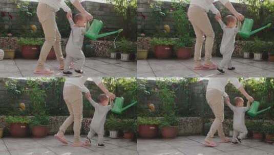 刚学会走路的小宝宝在花园里浇水高清在线视频素材下载