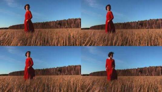 穿着猩红色连衣裙在风中流动的年轻女模特。高清在线视频素材下载