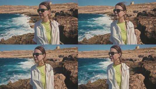 地中海生活方式的女人在海边沿着岩石散步的高清在线视频素材下载