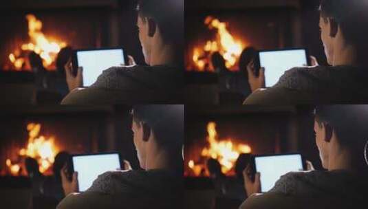 男人坐在壁炉旁玩电脑放松休息高清在线视频素材下载