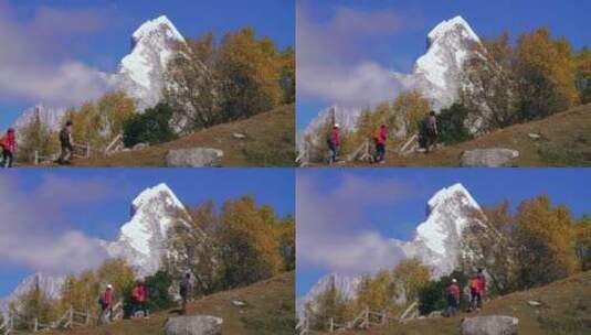 游人在四姑娘山幺妹峰雪山秋日蓝天下徒步高清在线视频素材下载