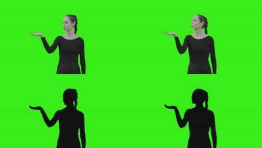 年轻女子通过绿屏吹气与虚拟实体交流。高清在线视频素材下载