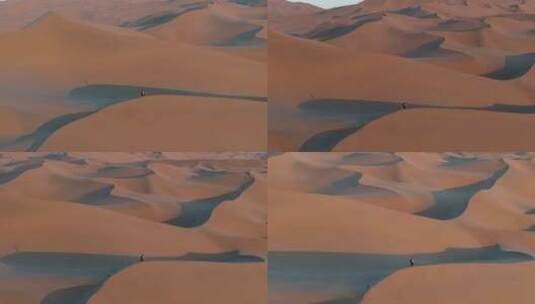 航拍男人行走在新疆库木塔格沙漠中高清在线视频素材下载