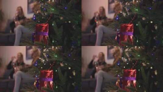 装饰圣诞树，背景是一对夫妇坐着喝酒高清在线视频素材下载