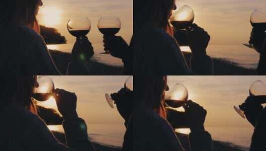 一对年轻夫妇在湖边日落时喝酒的剪影高清在线视频素材下载