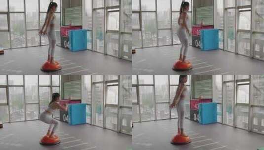一位女青年在健身房锻炼身体下蹲运动高清在线视频素材下载
