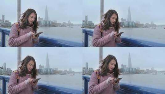 女孩在伦敦塔桥上使用手机高清在线视频素材下载